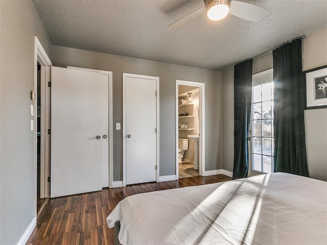 bedroom featuring dark wood-type flooring, ceiling fan, ensuite bathroom, and a textured ceiling