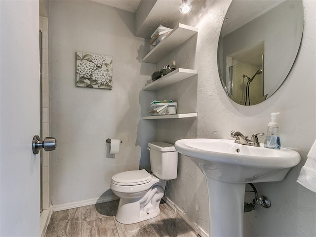 bathroom with walk in shower, sink, hardwood / wood-style floors, and toilet