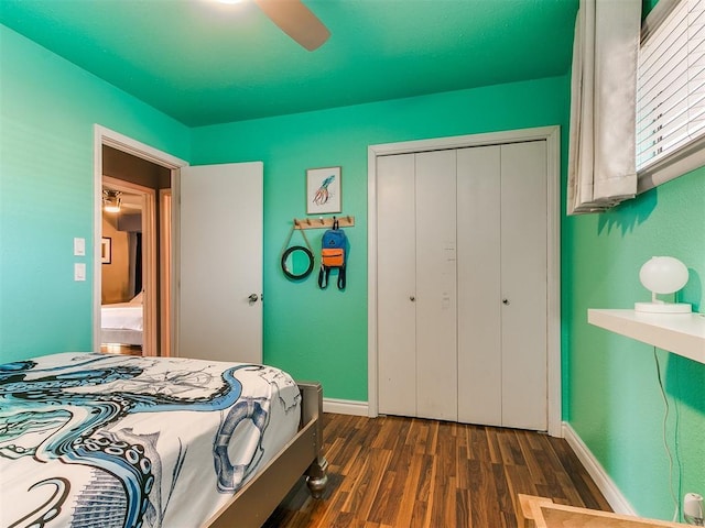 bedroom featuring dark wood-type flooring, ceiling fan, and a closet