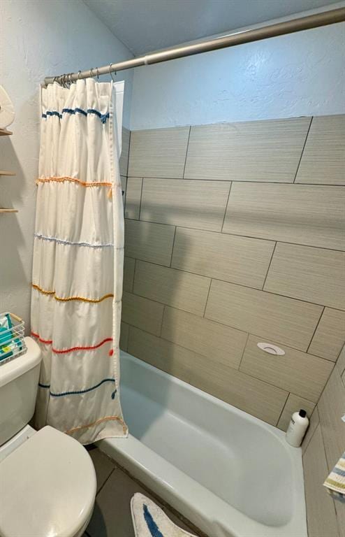 bathroom with toilet and shower / bath combo with shower curtain