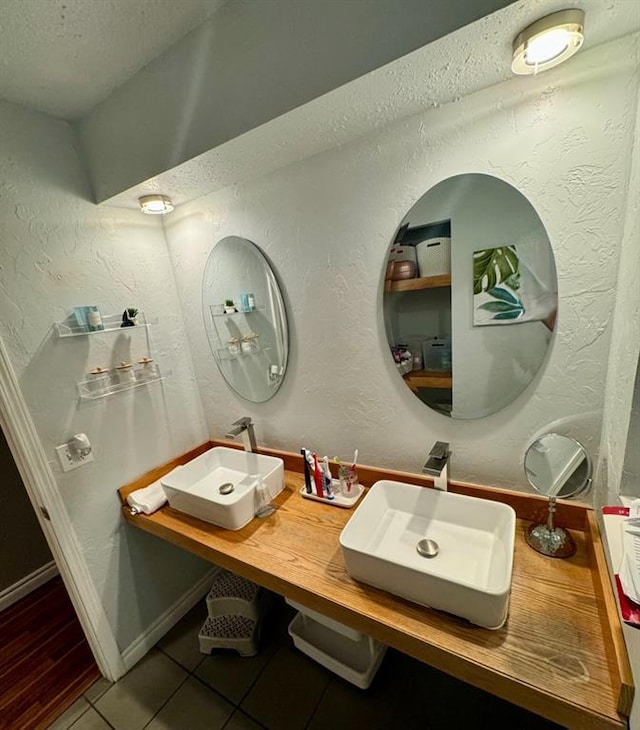 bathroom featuring tile patterned flooring, vanity, and a textured ceiling