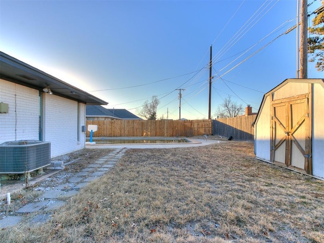 view of yard with cooling unit and a storage shed