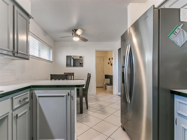 kitchen featuring gray cabinetry, light tile patterned floors, ceiling fan, and stainless steel refrigerator with ice dispenser