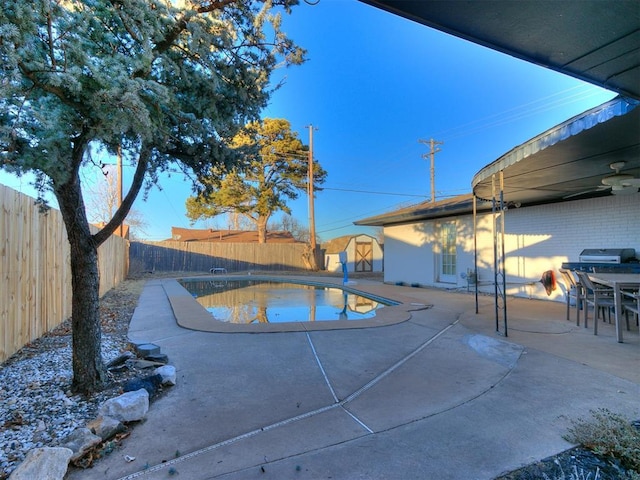 view of pool with a storage shed and a patio area