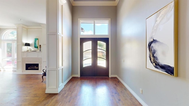 entryway featuring wood-type flooring, ornamental molding, and french doors