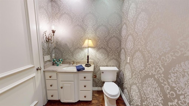 bathroom with vanity, hardwood / wood-style floors, and toilet