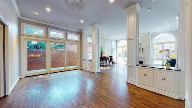 interior space with ornate columns, ornamental molding, and hardwood / wood-style flooring