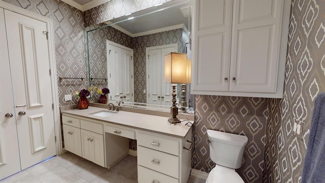 bathroom with ornamental molding, vanity, toilet, and tile patterned floors