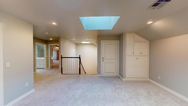 additional living space featuring a skylight and light carpet