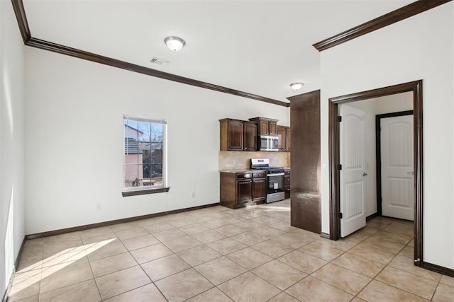 kitchen featuring light tile patterned flooring, crown molding, dark brown cabinets, appliances with stainless steel finishes, and decorative backsplash