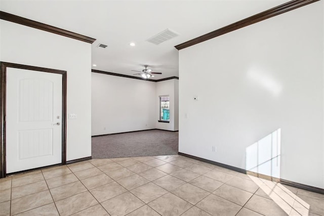 empty room featuring light tile patterned floors, crown molding, and ceiling fan