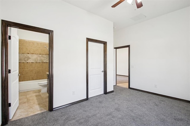 unfurnished bedroom featuring ensuite bath, light colored carpet, and ceiling fan