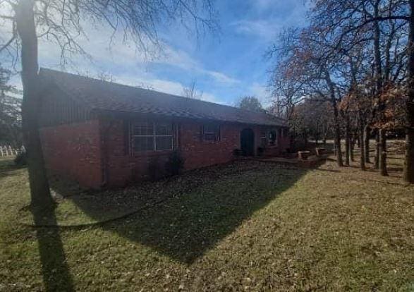 view of side of home with a yard