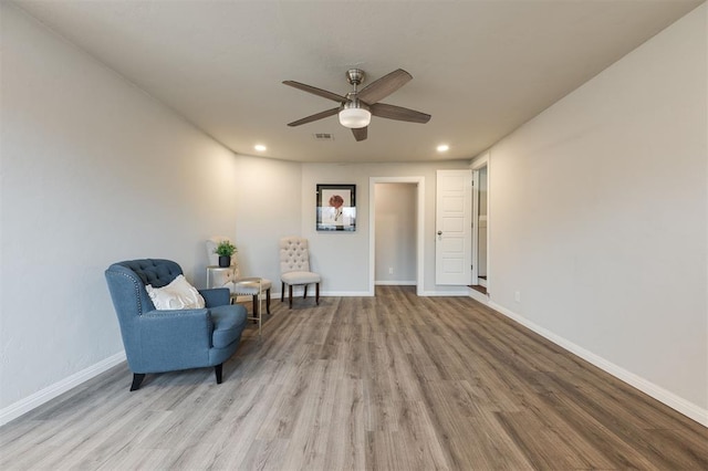 living area with ceiling fan and light hardwood / wood-style floors