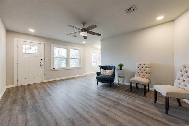 living area featuring dark hardwood / wood-style flooring and ceiling fan