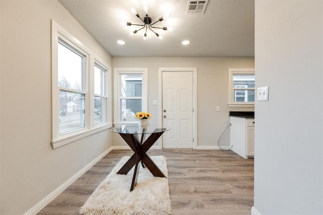 dining space with an inviting chandelier and light hardwood / wood-style floors