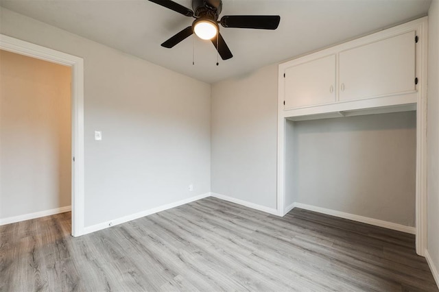 unfurnished bedroom with ceiling fan, light wood-type flooring, and a closet