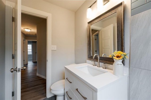 bathroom featuring hardwood / wood-style flooring, vanity, and toilet