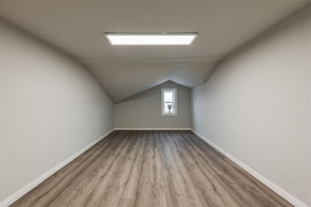 additional living space with vaulted ceiling and light hardwood / wood-style floors