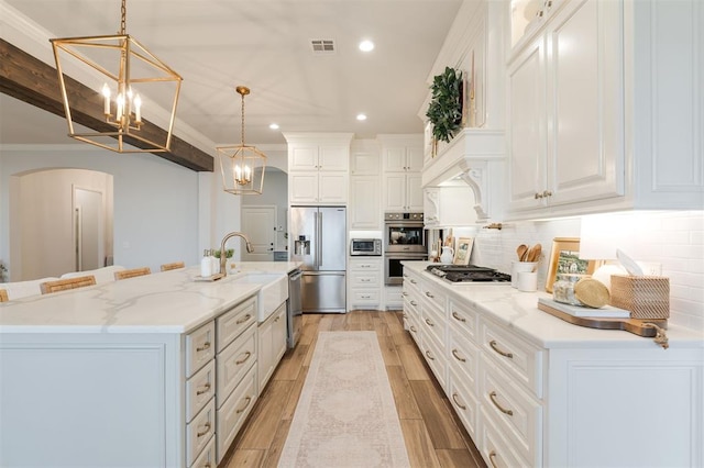 kitchen featuring white cabinetry, visible vents, appliances with stainless steel finishes, decorative backsplash, and light wood finished floors