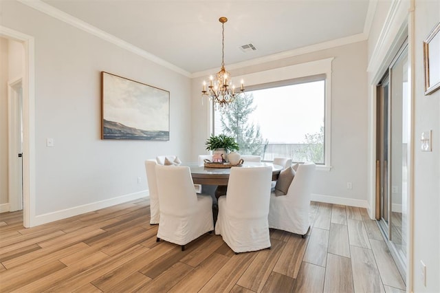 dining space featuring a chandelier, ornamental molding, light wood-type flooring, and visible vents