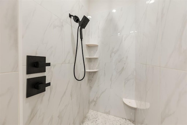 bathroom featuring a marble finish shower