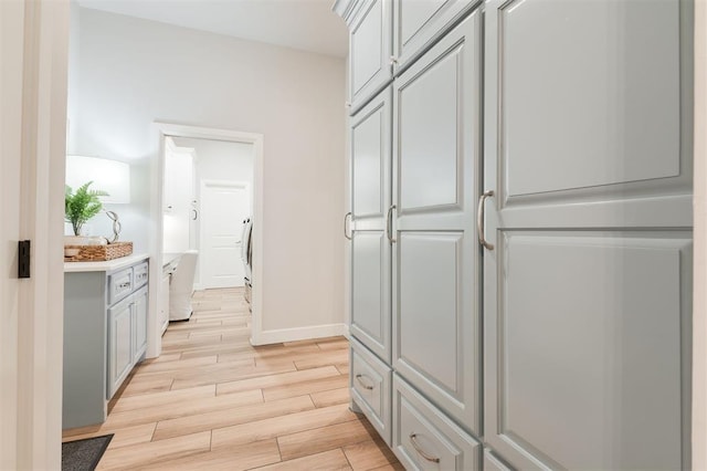 interior space featuring baseboards, light countertops, and wood finish floors