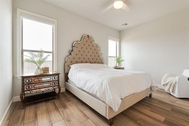 bedroom featuring light wood-style flooring, visible vents, and baseboards