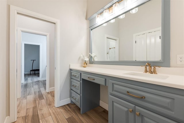 bathroom featuring vanity, baseboards, and wood finished floors