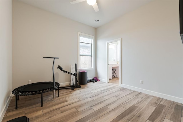 workout room with baseboards, visible vents, ceiling fan, and wood finish floors