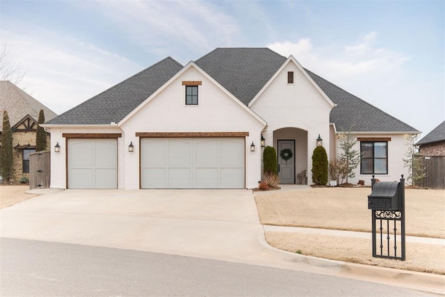 view of front of house featuring a garage, concrete driveway, a shingled roof, and fence