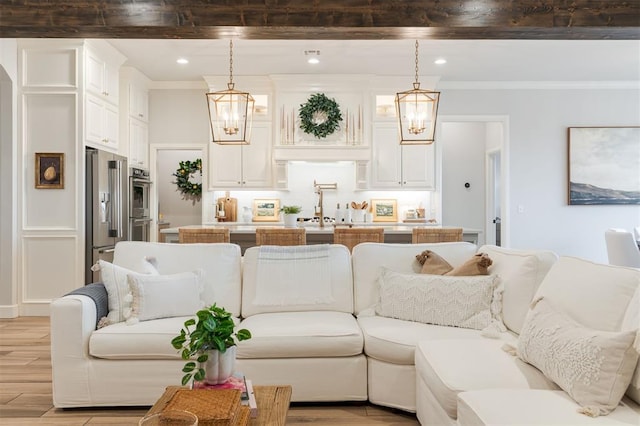 5616 Windstone Dr, Norman, OK 73072 - living area featuring light wood-style floors, ornamental molding, and a chandelier