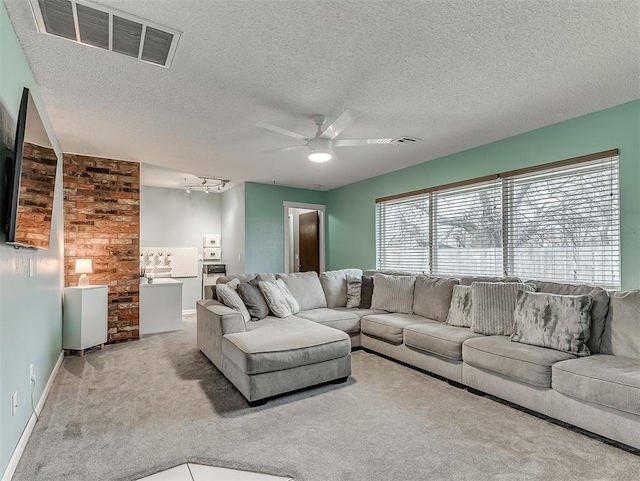 living room with ceiling fan, light colored carpet, and a textured ceiling