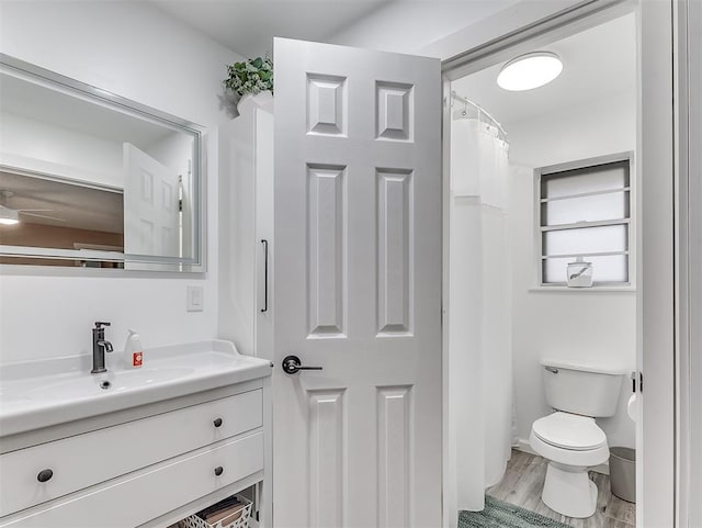 bathroom featuring vanity, hardwood / wood-style floors, toilet, and a shower with shower curtain