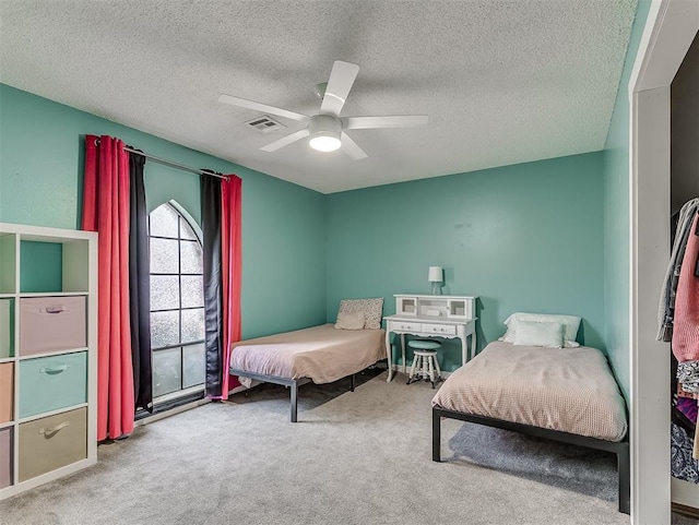 bedroom featuring ceiling fan, light carpet, and a textured ceiling