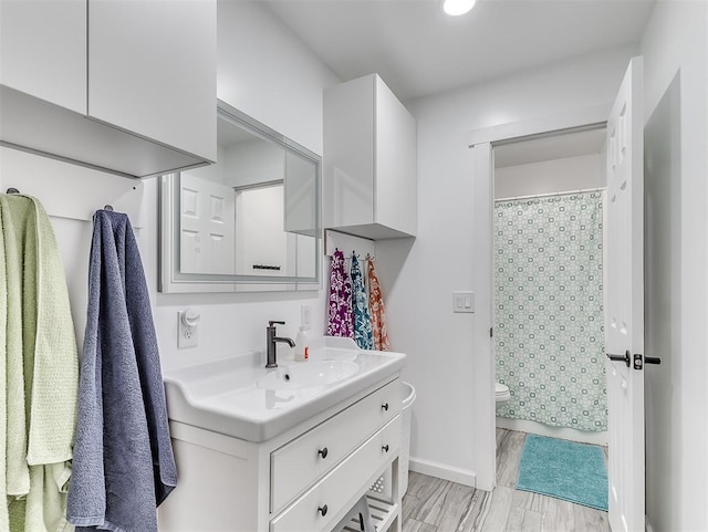 bathroom with vanity, curtained shower, toilet, and hardwood / wood-style flooring