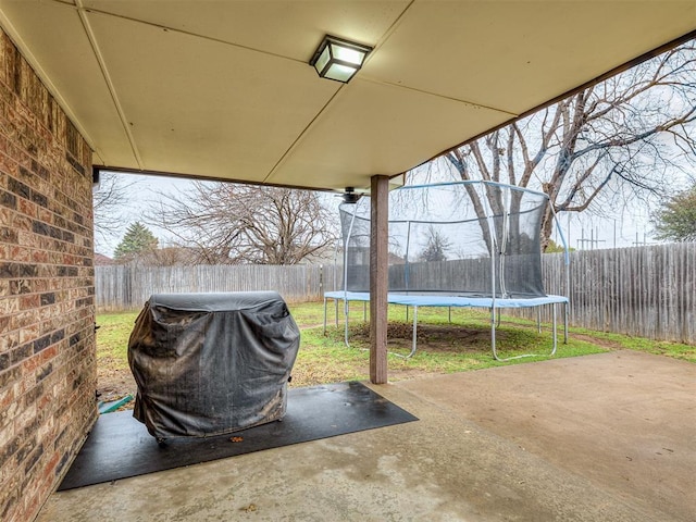 view of patio with a grill and a trampoline