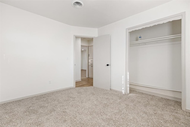 unfurnished bedroom with a closet and light carpet