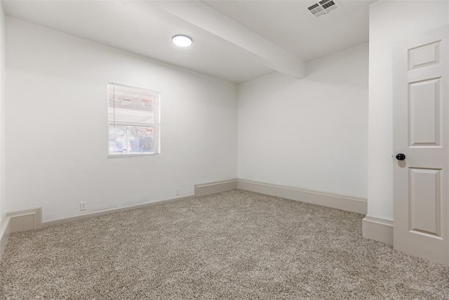 carpeted spare room featuring beamed ceiling