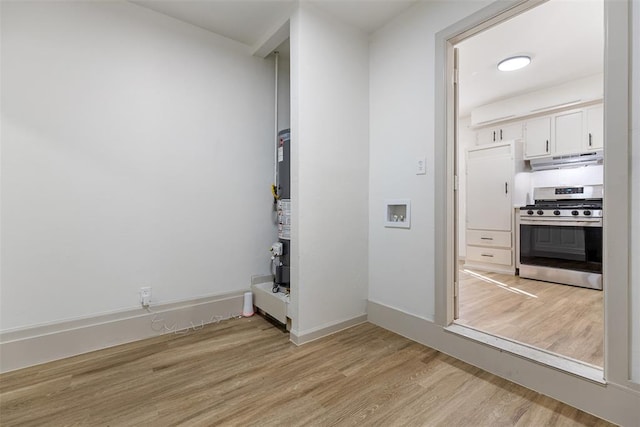 interior space featuring water heater, gas range, white cabinets, and light wood-type flooring