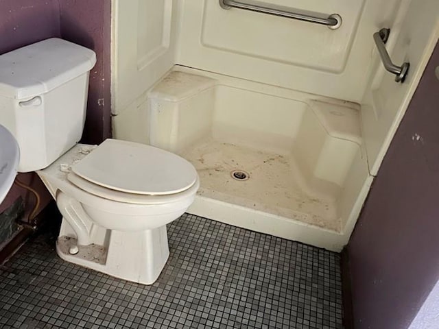 bathroom featuring a shower, tile patterned floors, and toilet