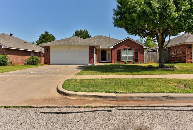 single story home featuring a garage and a front yard