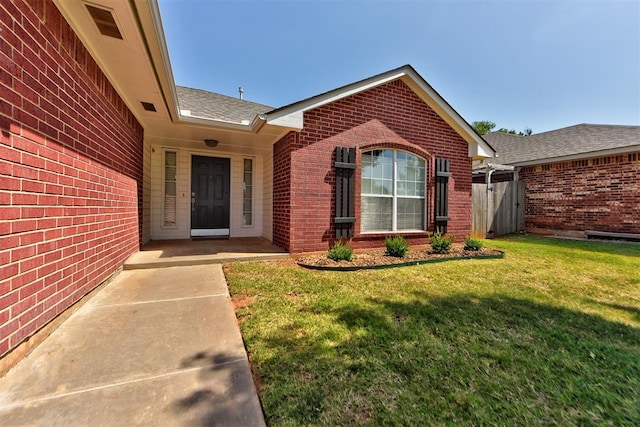 property entrance with a lawn