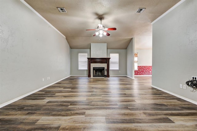 unfurnished living room with a tiled fireplace, crown molding, dark hardwood / wood-style floors, and ceiling fan