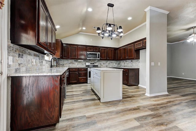 kitchen with backsplash, stainless steel appliances, a center island, ornamental molding, and ceiling fan with notable chandelier