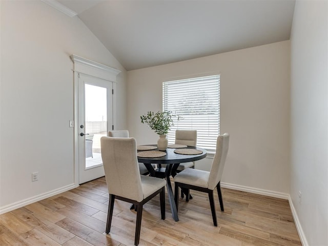 dining area featuring vaulted ceiling and light wood-type flooring