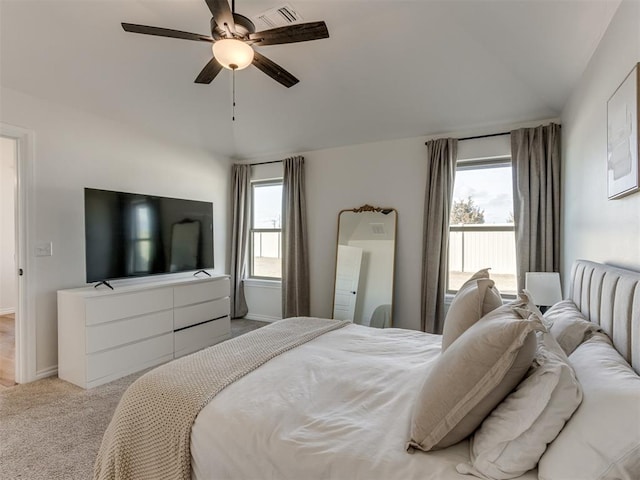 carpeted bedroom featuring multiple windows and ceiling fan