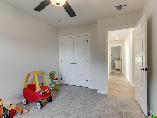 rec room featuring light carpet and ceiling fan