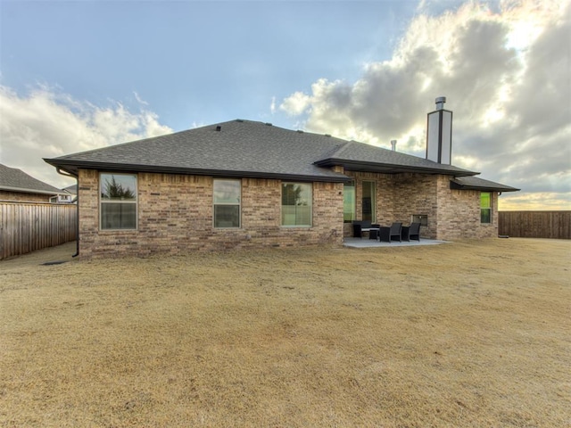 rear view of house with a yard and a patio area