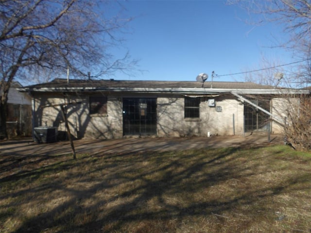 back of property with cooling unit and a lawn